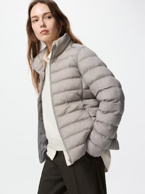 A model wearing a light gray men's nylon puffer jacket with horizontal quilting.