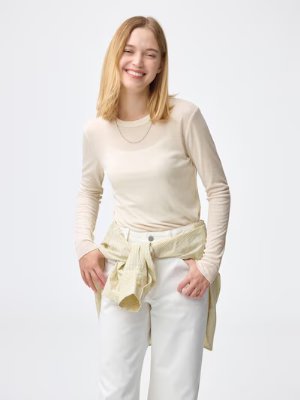 Model wearing a light-colored long-sleeve crew-neck T-shirt.