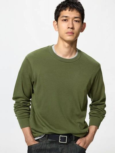 Male model wearing an olive-green crew-neck long-sleeve T-shirt, shown from the waist up.