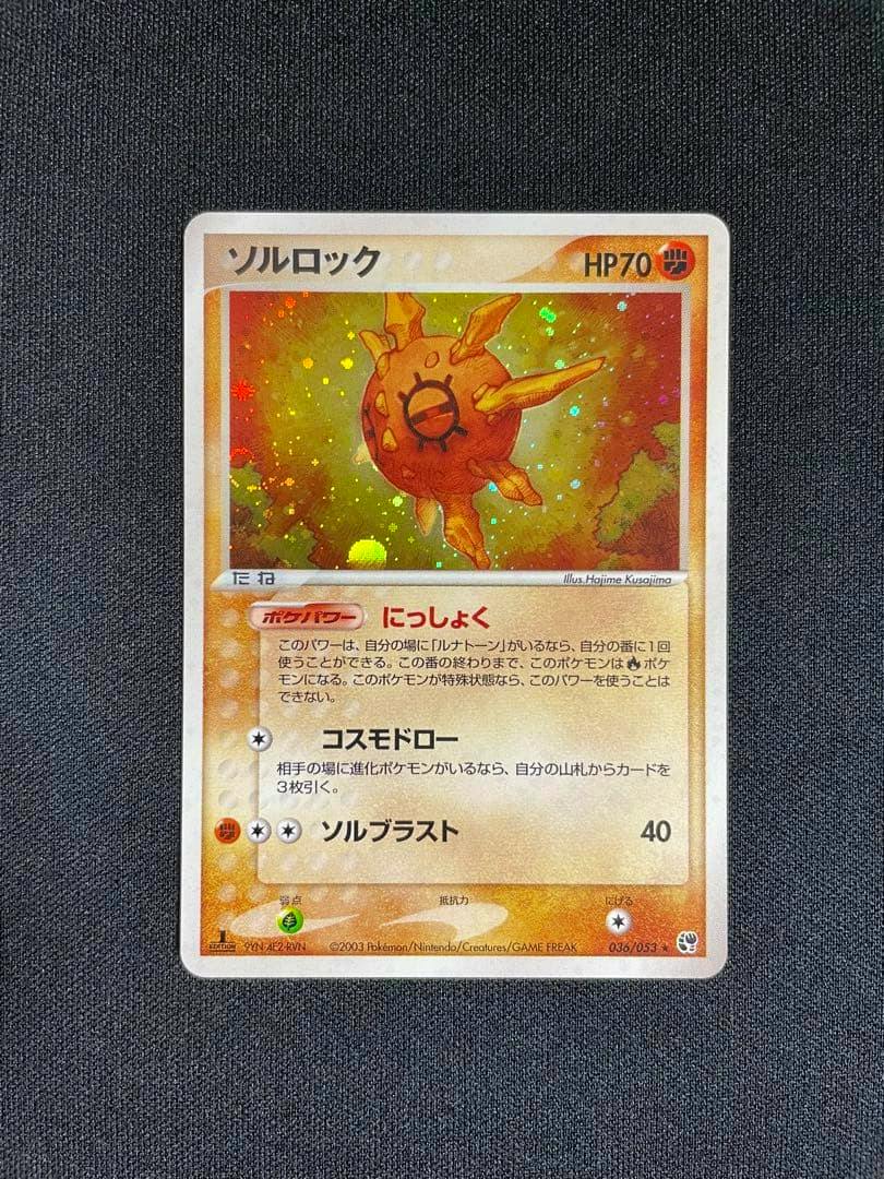 Full-frame photo of the ソルロック ★ trading card (036/053) with holographic artwork on a dark textured background.