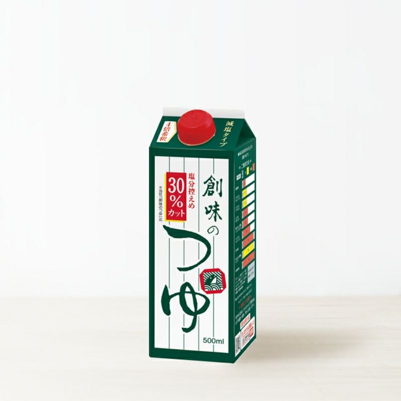 A green-and-white 500ml carton of 創味のつゆ 減塩タイプ (reduced-sodium tsuyu) with a red screw cap.