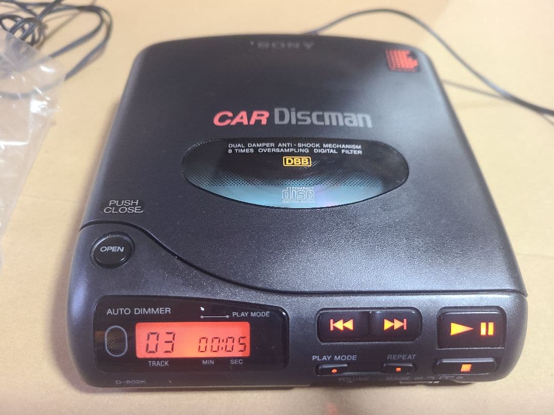 Close-up of a SONY CAR Discman portable CD player showing the top lid and front control panel with illuminated display.