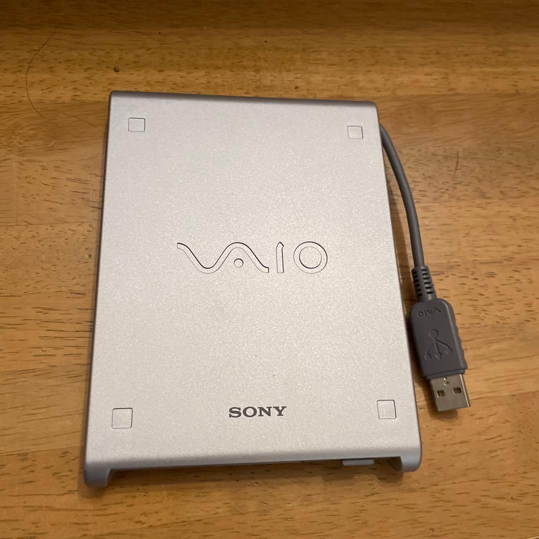 Top view of a silver Sony VAIO external floppy disk drive (PCGA-UFD5) with attached USB cable.