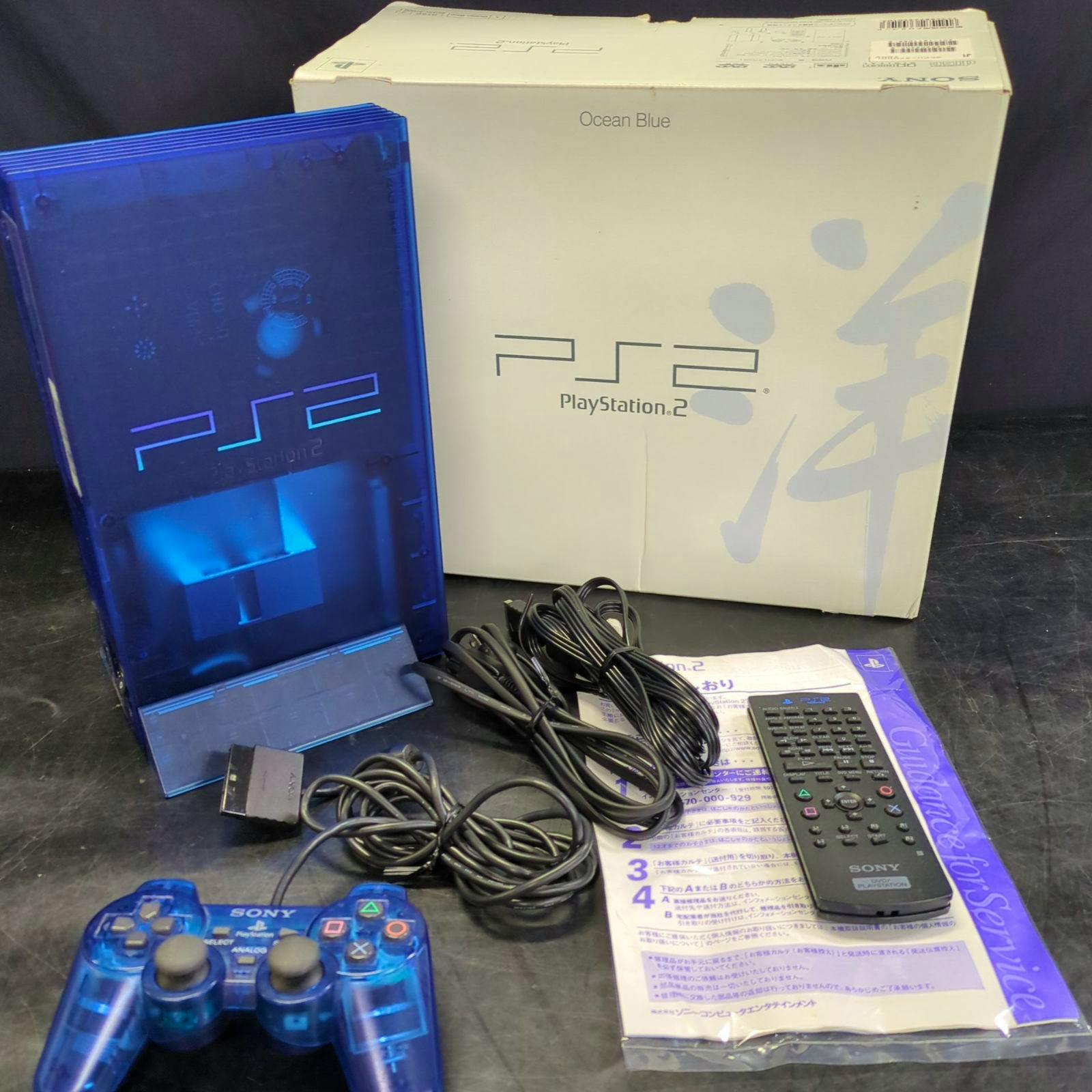 Ocean Blue PlayStation 2 console with matching translucent blue controller, cables, remote, manual, and original box.