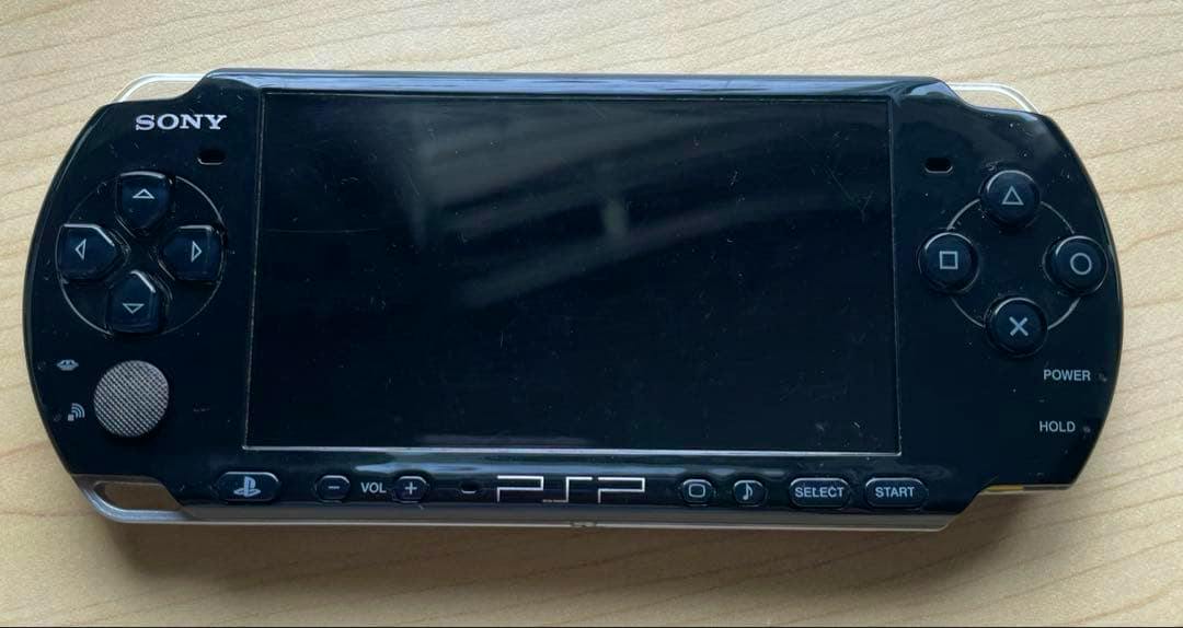 Front view of the Sony PSP3001 piano black handheld game console showing the screen and front controls.