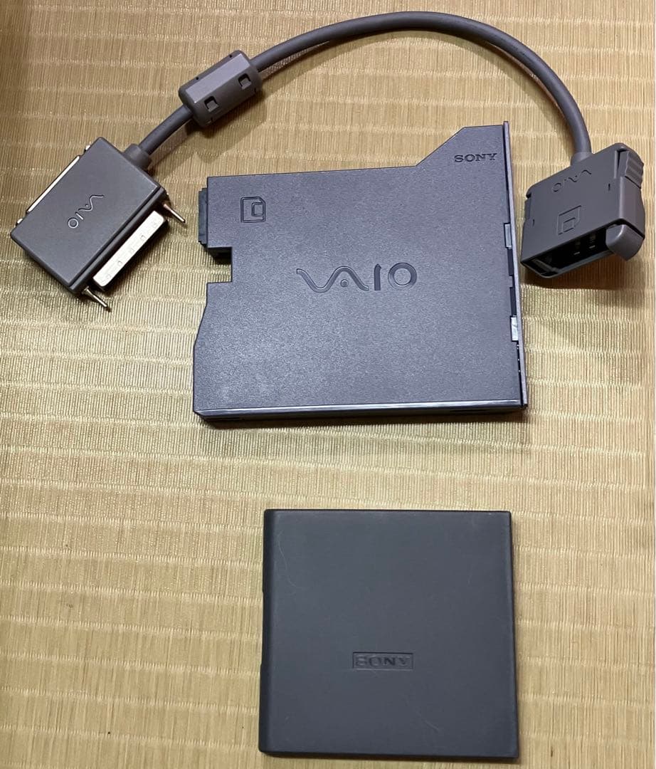 Sony VAIO 3.5-inch external floppy disk drive with attached cable and a square protective cover on a textured surface.