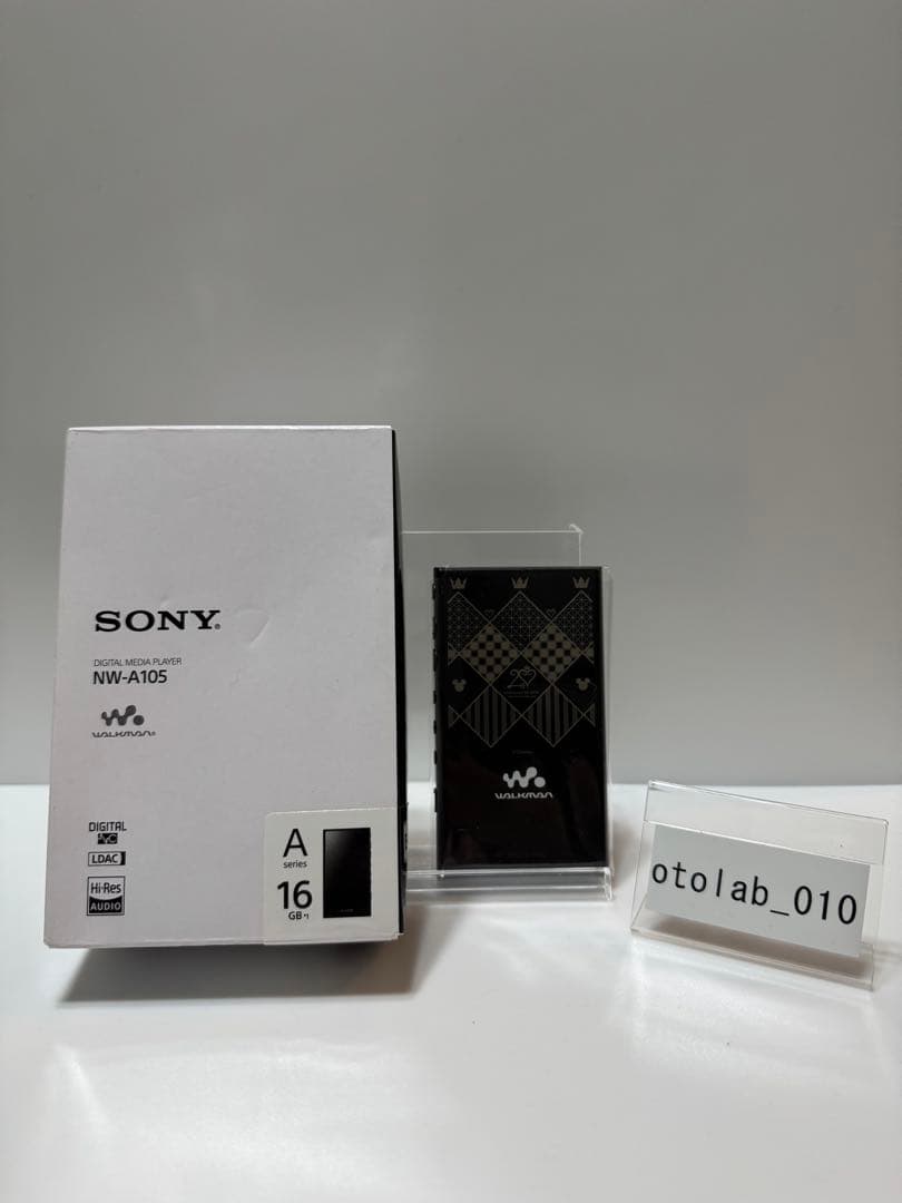 SONY NW-A105 Walkman in a clear stand shown next to its white retail box.
