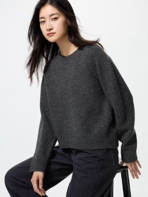 Model wearing a dark gray crew-neck sweater against a plain white background.