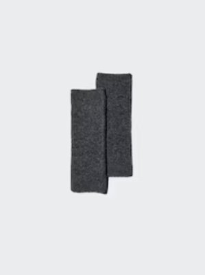 A pair of dark gray knit arm warmers laid flat on a light background.