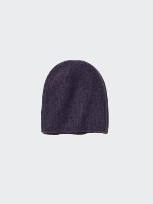 A dark purple knit beanie photographed flat on a light gray background.