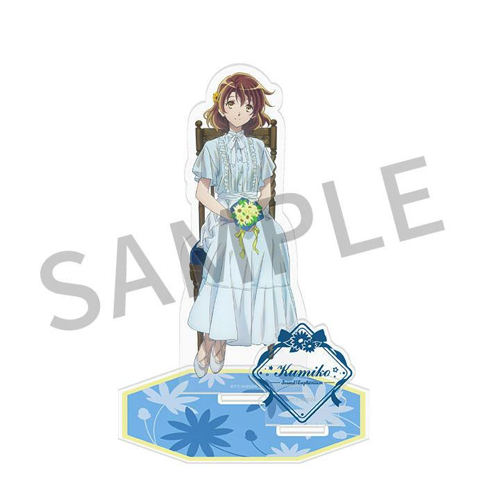 Acrylic stand of Kumiko in a white dress seated on a chair holding a bouquet on a blue decorative base against a white background.
