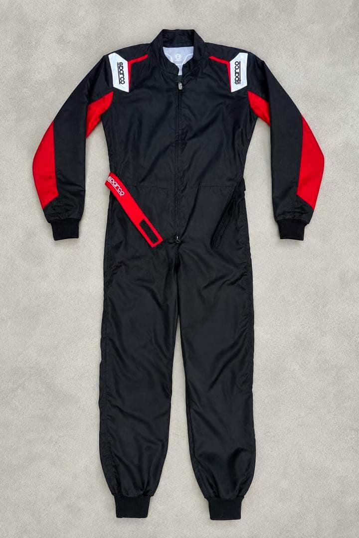 Front view of a black and red SPARCO kart racing suit laid flat on a light background.