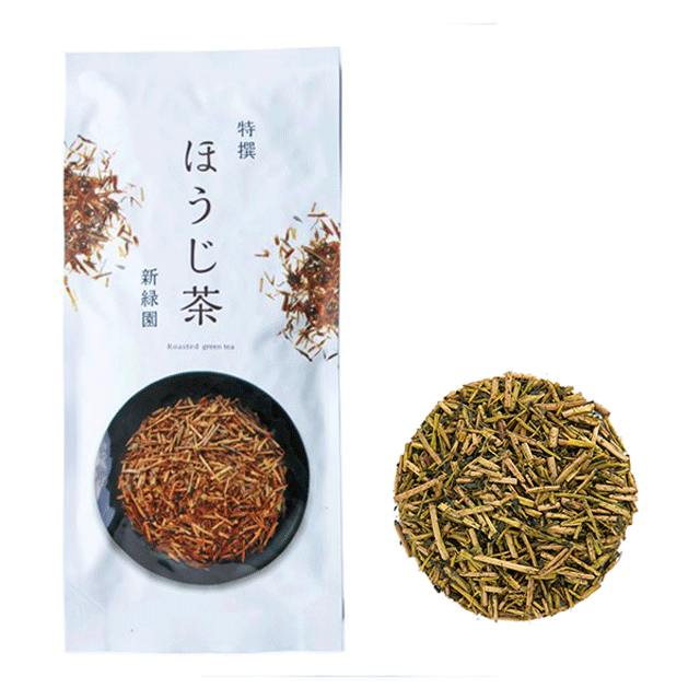 White product pouch labeled 'ほうじ茶' beside a circular pile of loose roasted green tea leaves.