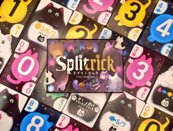Top-down photo of the board game 'スプリトリック' showing the game's box and many numbered cat-themed cards.