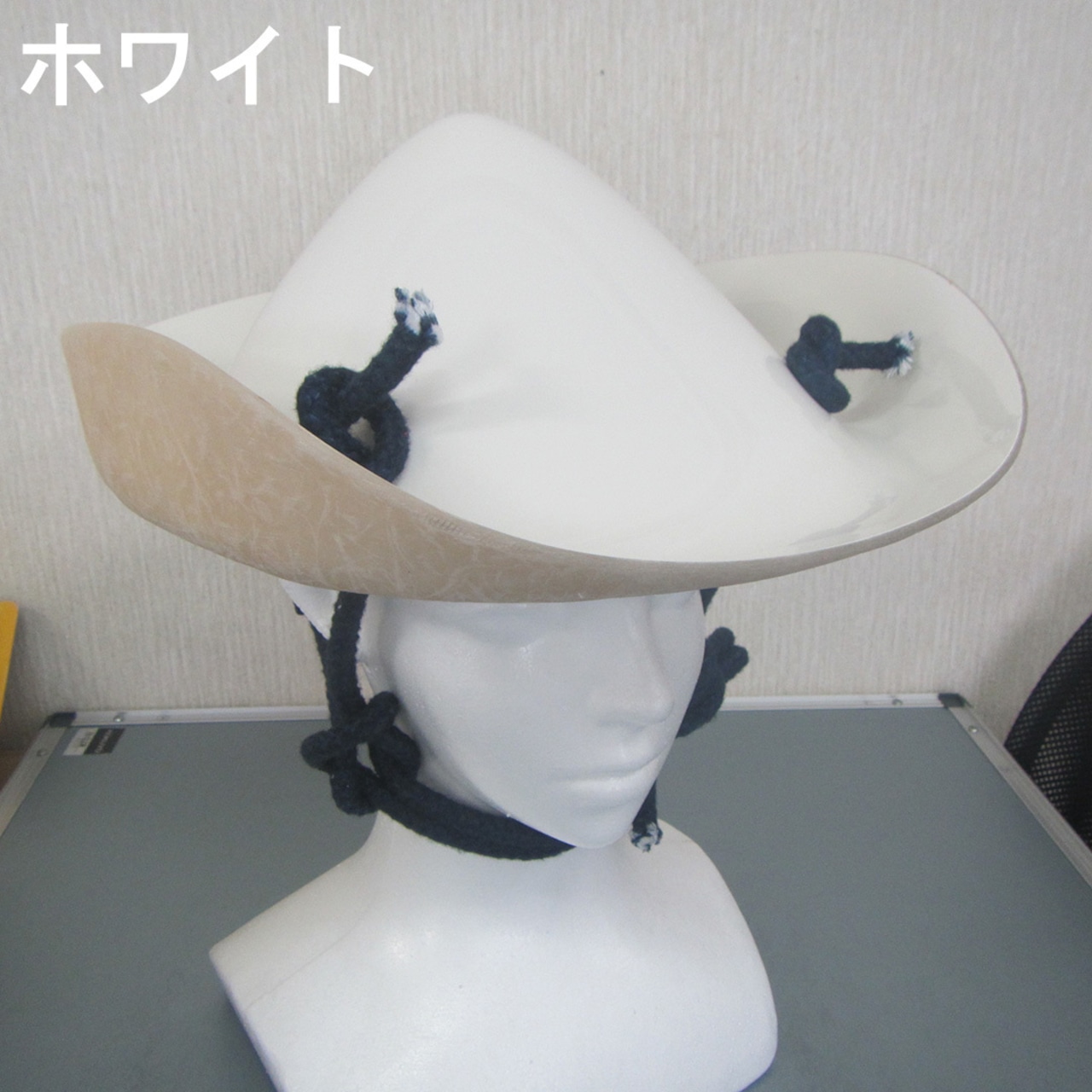 White sports yabusame jinkasa helmet on a mannequin head with black chin cords.