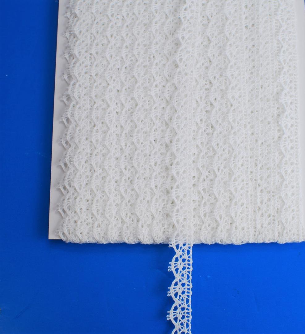 Off-white 12mm lace trim wound on a card and displayed on a blue background.