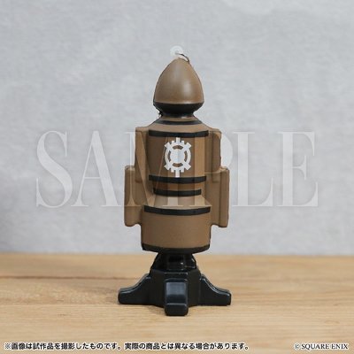 Rear view of the Squeezable Lanocean Dummy plastic figure standing on a small black base on a wooden surface.
