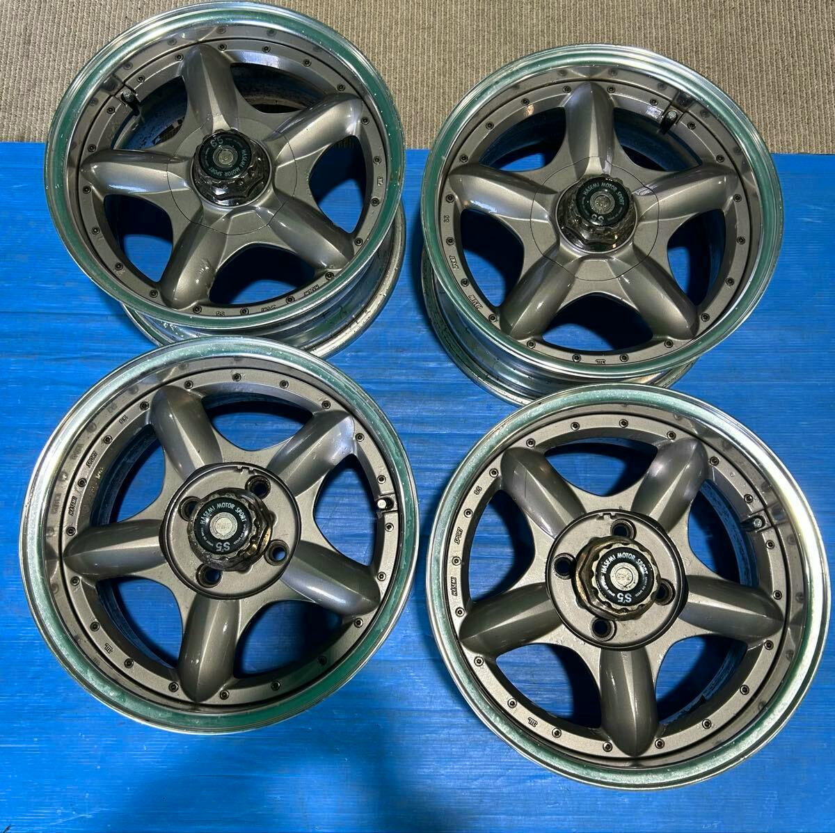 Four SSR 15-inch aluminum car wheels with five-spoke centers arranged on a blue tarp.