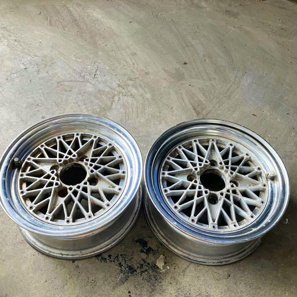 Pair of SSR FM (Formula Mesh) car wheels shown from the front with mesh centers and polished lips on a concrete floor.