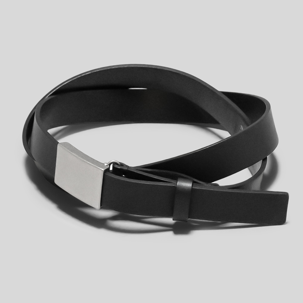 A black cow leather belt coiled with a rectangular silver buckle on a gray background.