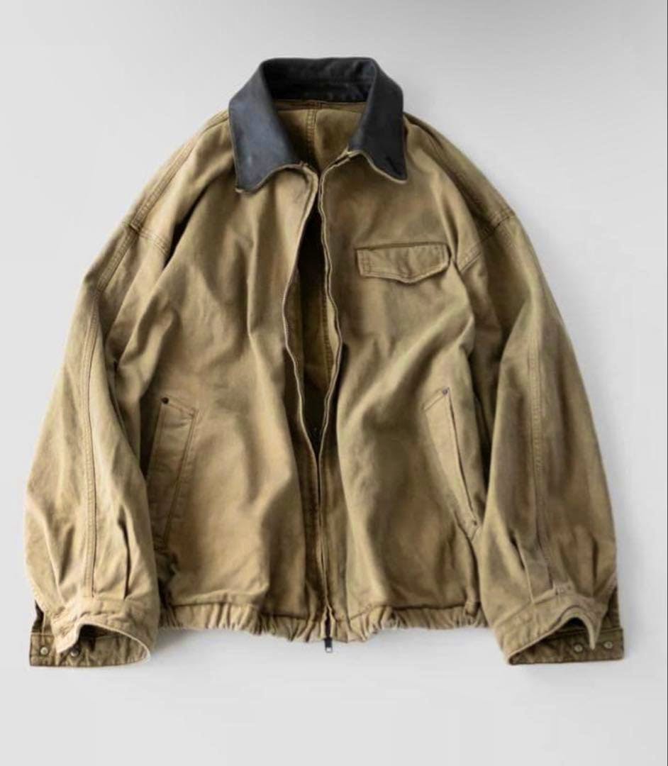 Flat-lay of a sulfur-dyed vintage men's zip jacket showing the front, dark collar, pockets, and zipper.