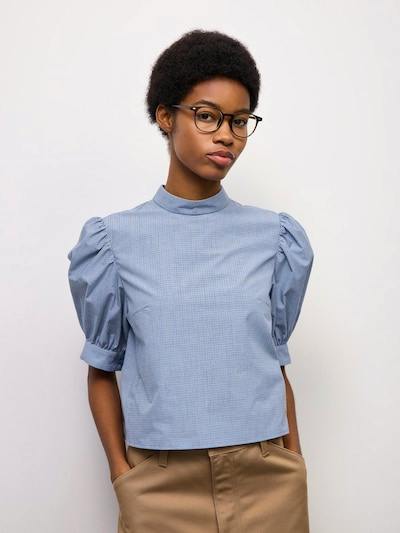 Front view of a model wearing the light-blue stand-collar women’s blouse with puffed mid-length sleeves.