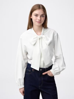 Model wearing a white stand-collar polyester blouse with long sleeves and a front bow.
