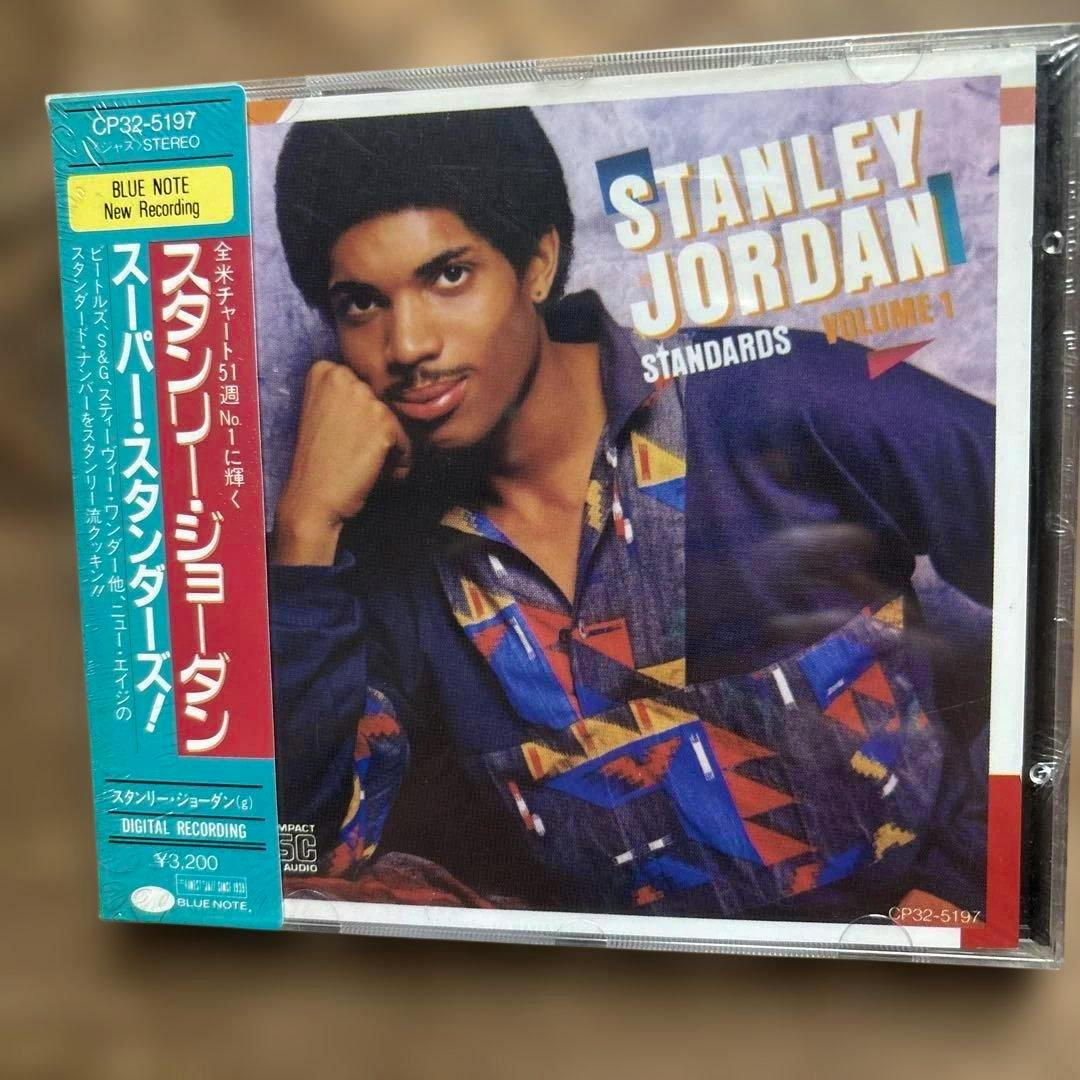 Front of a shrinkwrapped Stanley Jordan CD showing the album cover portrait and a Japanese obi strip.