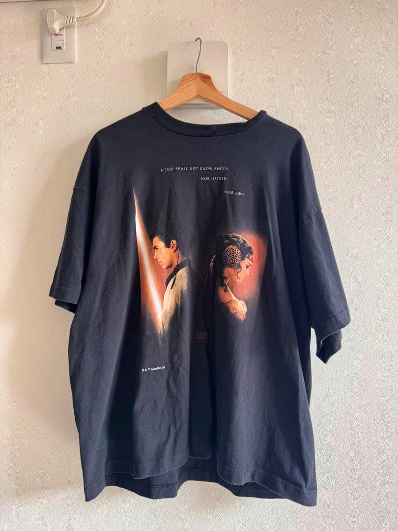 Front of a black men's cotton Star Wars T-shirt with Anakin and Padmé artwork hanging on a wooden hanger.