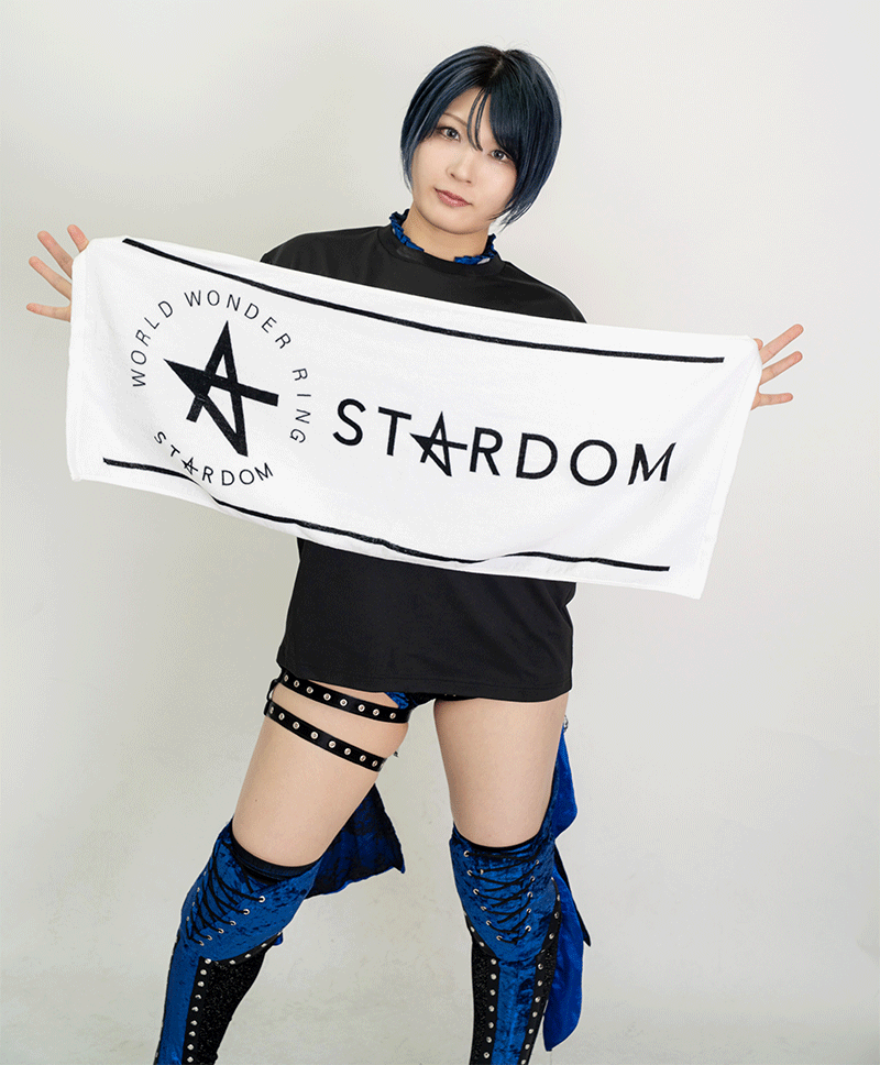 Person holding a white STARDOM circle face towel showing the circular logo and STARDOM text.