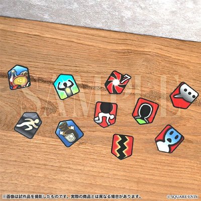 Photo of several small status-effect flake stickers with colorful icons arranged on a wooden surface.