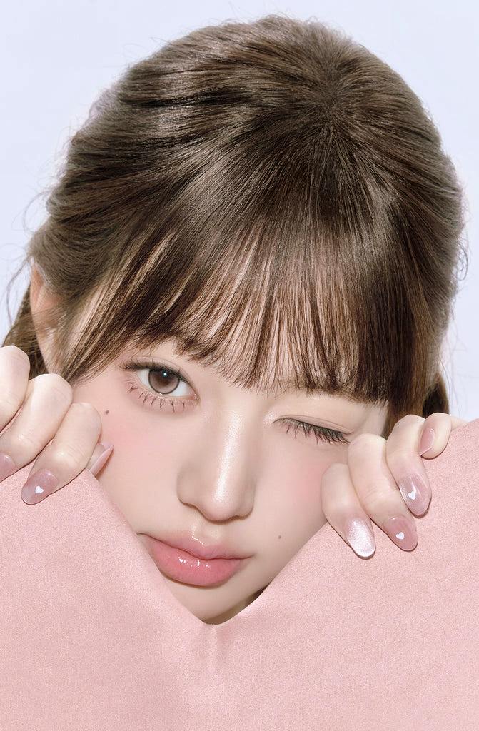 Close-up of a model winking while wearing the Stay Pretty Kristin 1Day contact lens in baby pink.