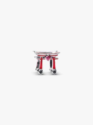 A sterling silver charm shaped like a torii gate with red enamel accents on a white background.