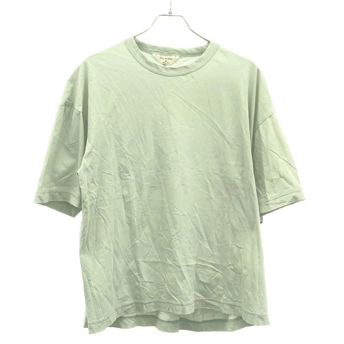 Mint-green STILL BY HAND cotton T-shirt (size 50) hanging on a hanger, front view.