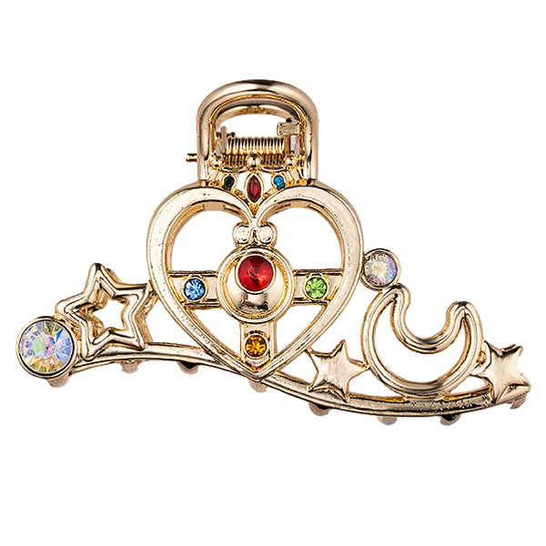 Gold-tone hair clip in a Cosmic Heart Compact design with a heart, crescent moon, stars, and multicolored gemstones.