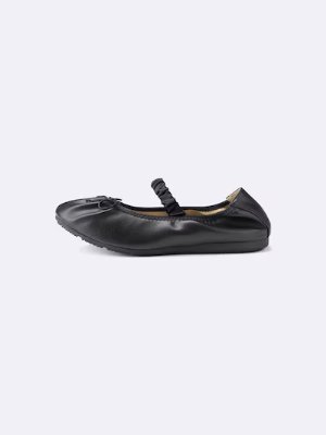 Side view of a black strap ballet sneaker on a light background.