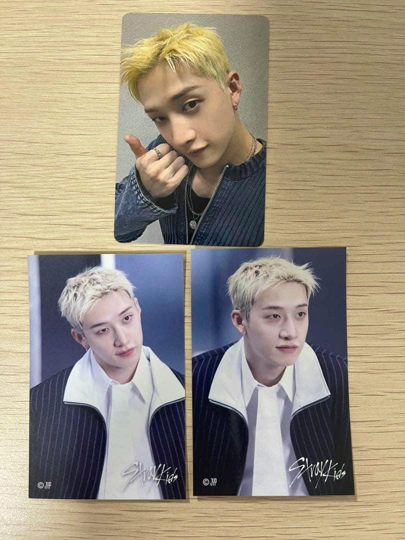 Three photocards on a wooden surface: one selfie-style card at top and two portrait-style cards below.