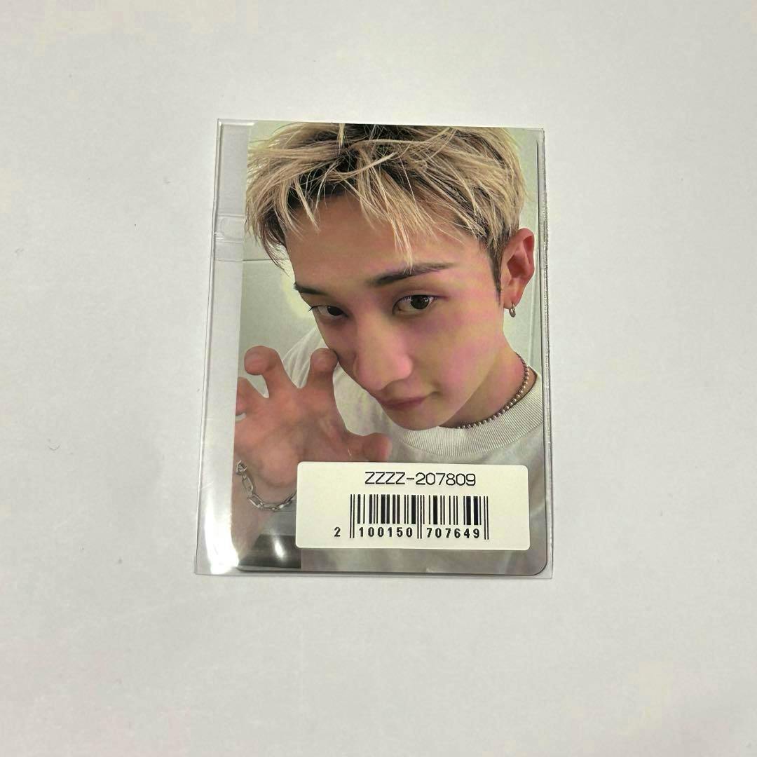 Photocard showing a close-up of a person in a plastic sleeve with a barcode sticker on the lower edge.