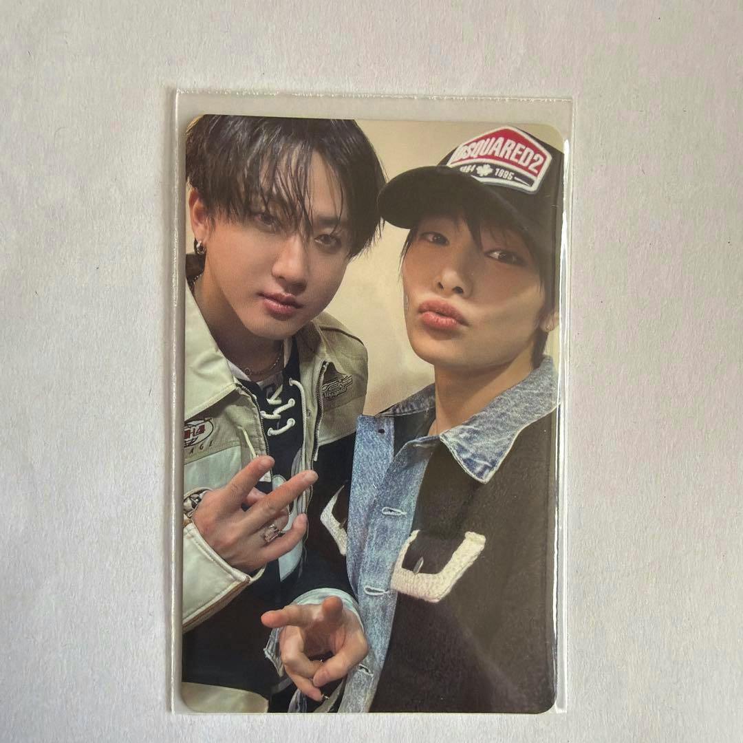 Photocard showing two people posing together in a clear plastic sleeve on a white background.