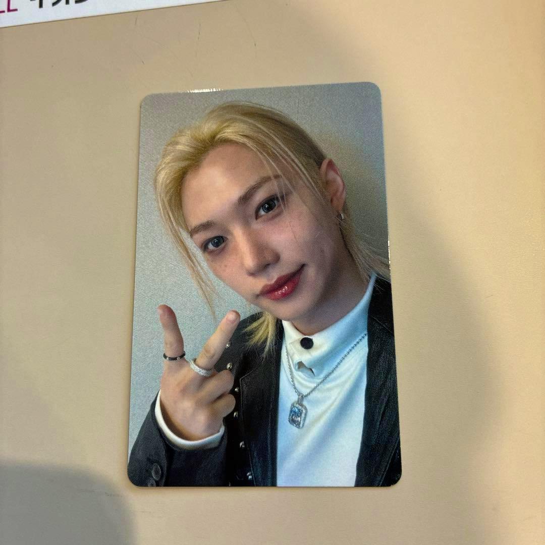 Photocard for a Straykids 9/5 Nagoya event showing a blond member making a peace sign on a beige surface.