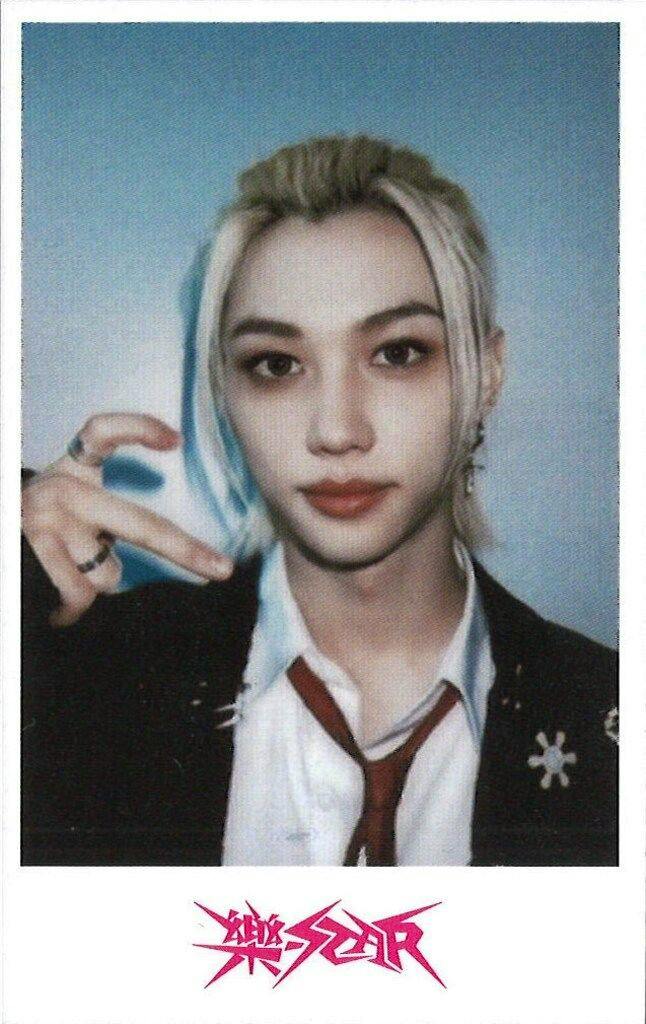 Photocard front showing a head-and-shoulders portrait of Felix from StrayKids with a blue background and a pink 樂-STAR logo at the bottom.