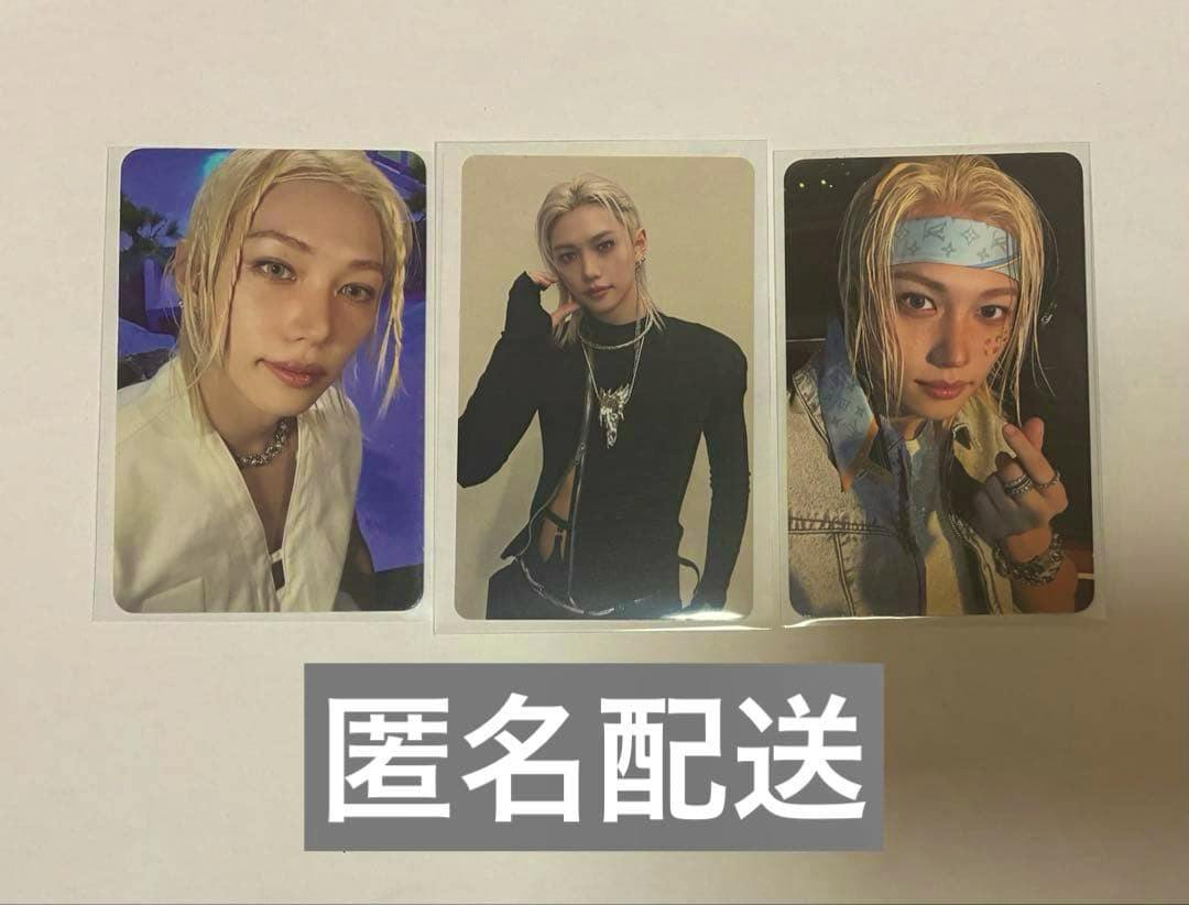 Three photocard trading cards laid side-by-side on a white surface, each showing a portrait of the artist, with a gray label containing Japanese text at the bottom.