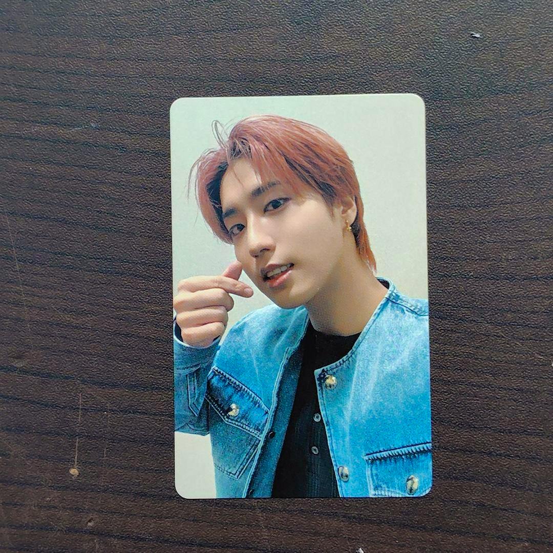 Front of the photocard showing a person wearing a blue denim jacket making a finger-heart gesture.