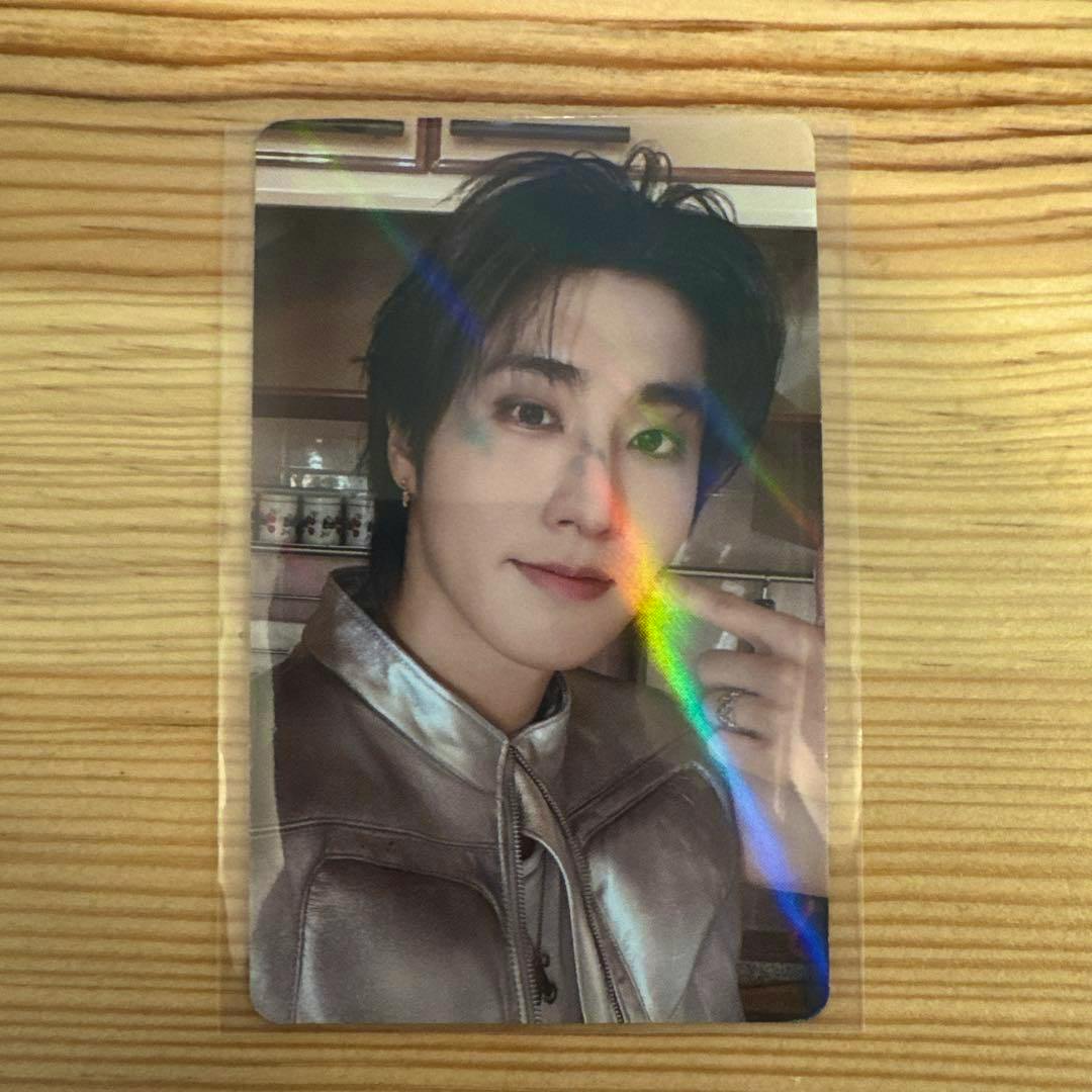 Front of the Stray Kids ハン This&That HMV特典A holographic photocard showing Han's portrait in a sleeve on a wooden surface.