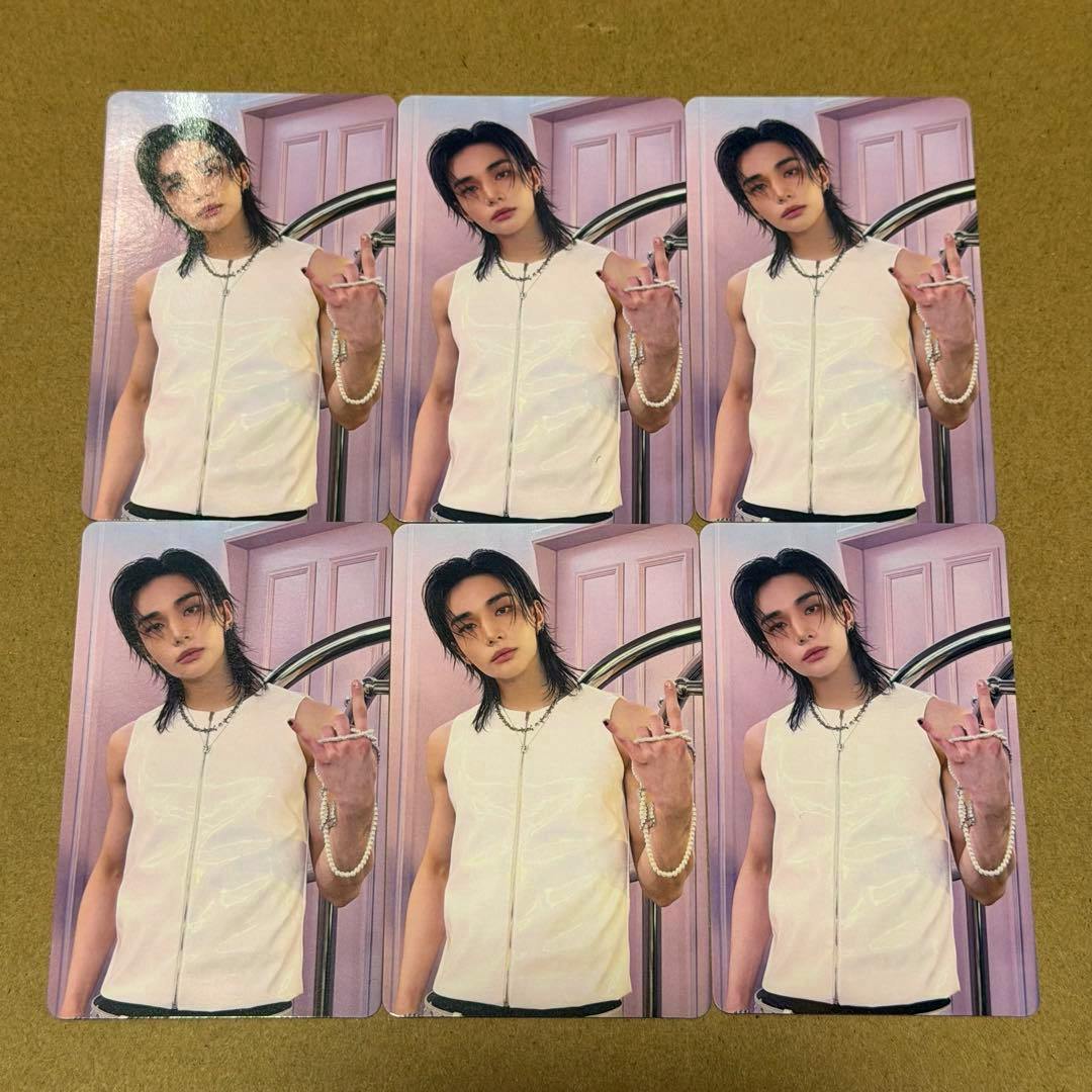 Six identical photocards showing a person wearing a sleeveless white zip vest arranged in two rows on a brown surface.