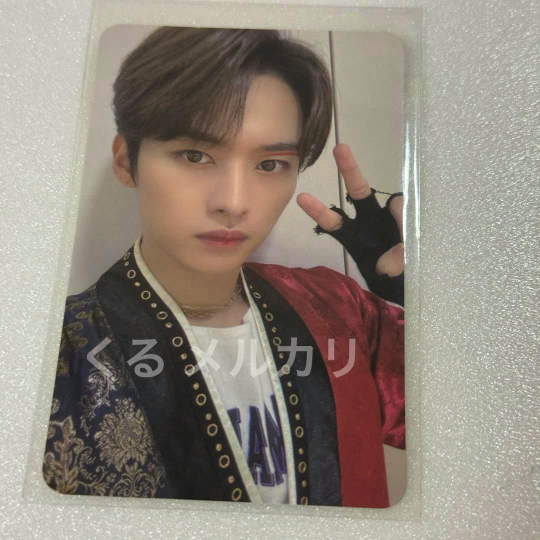 Front of the photocard showing a person's portrait wearing a patterned jacket and making a two-finger (peace) gesture.
