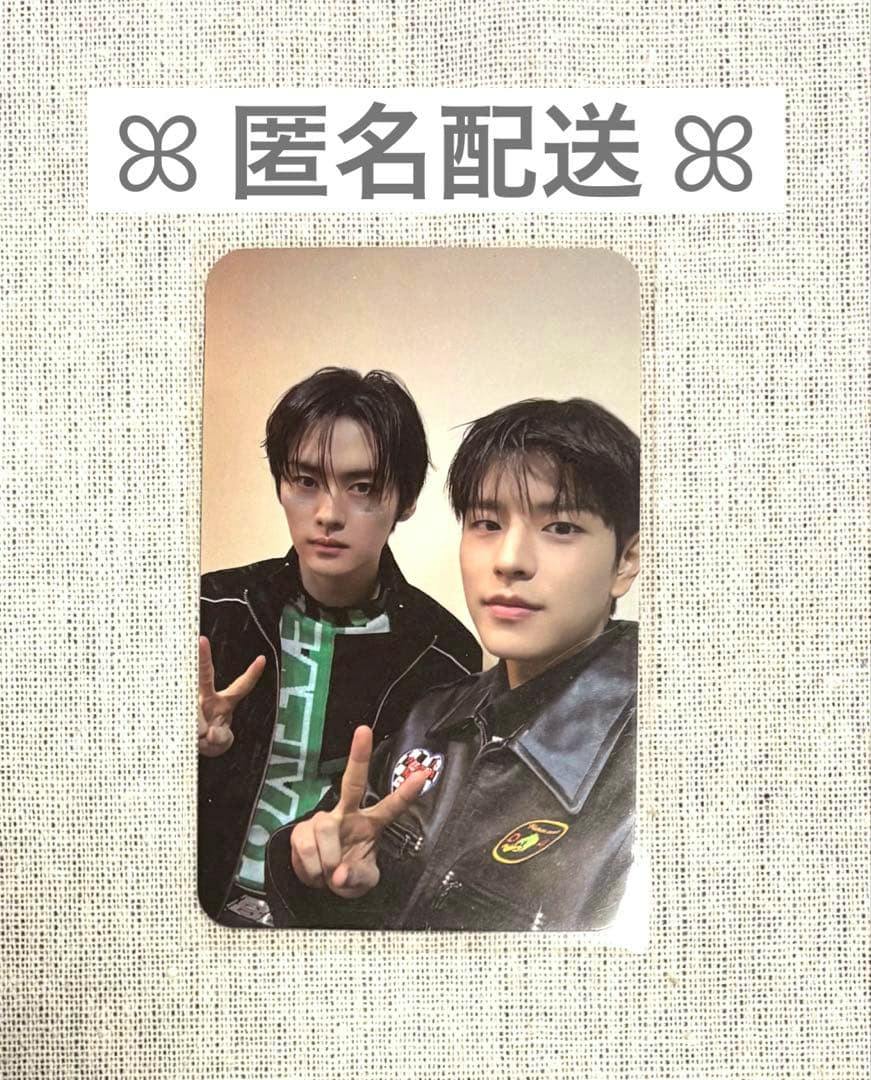 Photocard front showing two Stray Kids members posing and making peace signs on a textured fabric background.