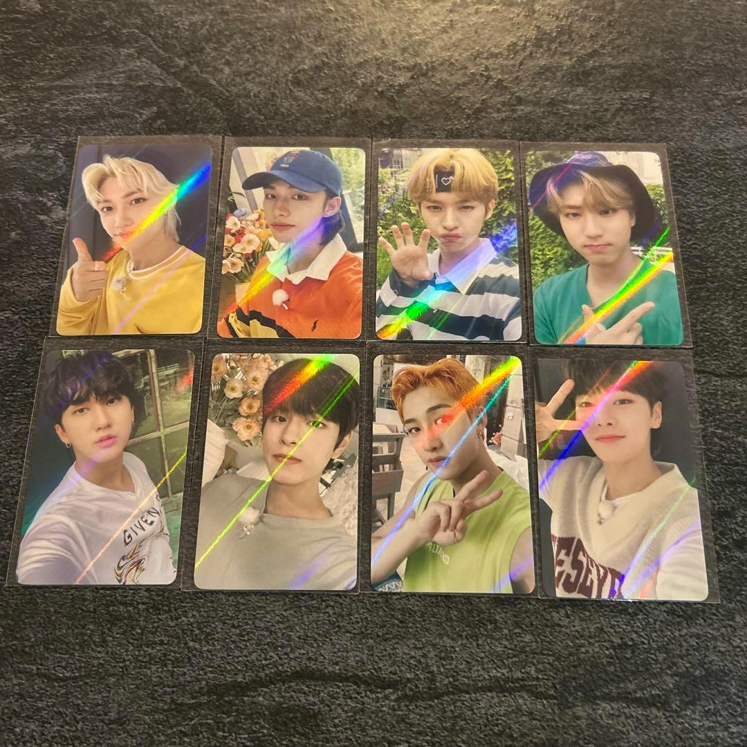 Eight Stray Kids NOEASY photocards showing member portrait fronts with holographic reflections laid out on a dark textured surface.