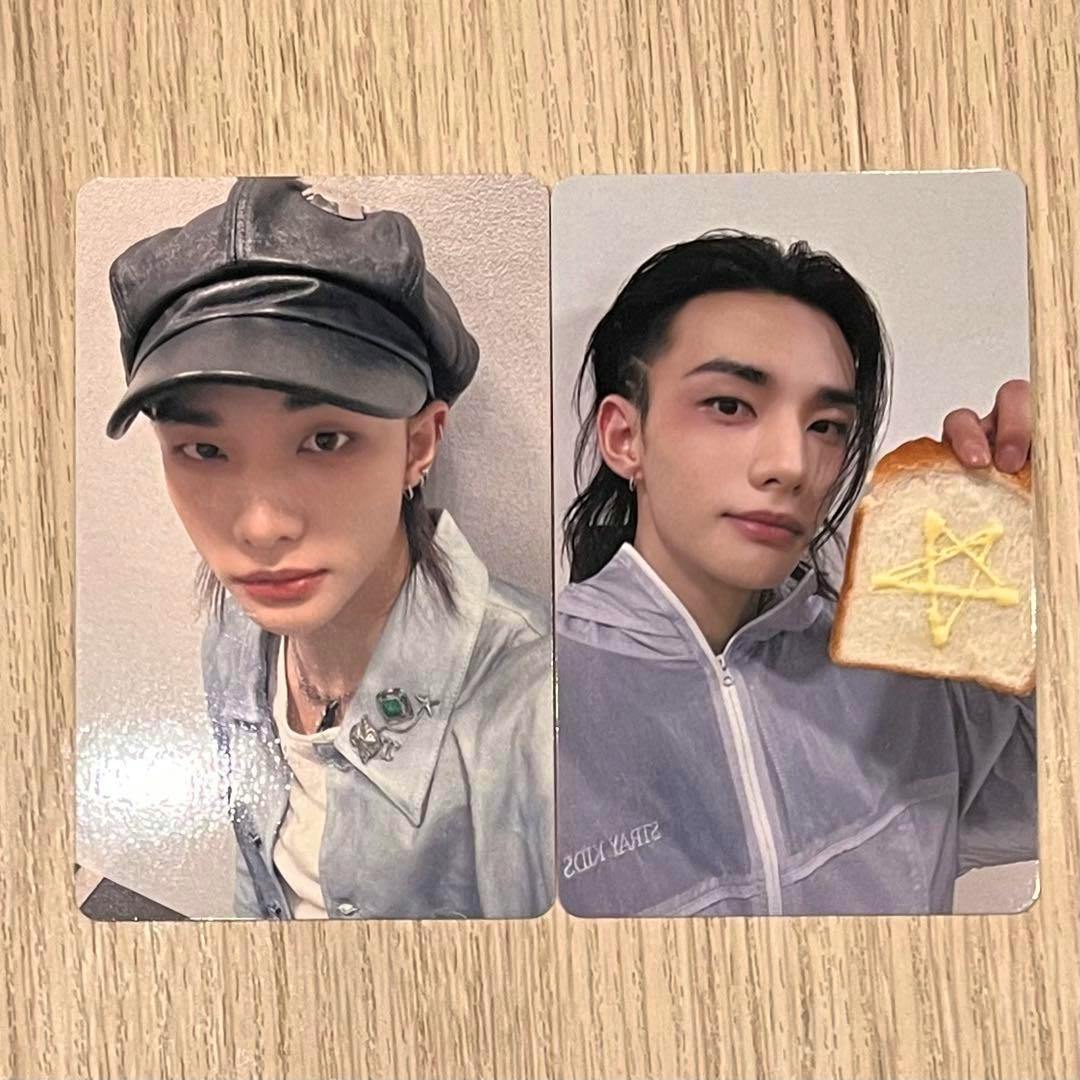 Two Stray Kids RUN IT photocard fronts featuring Hyunjin shown side by side on a wooden surface.