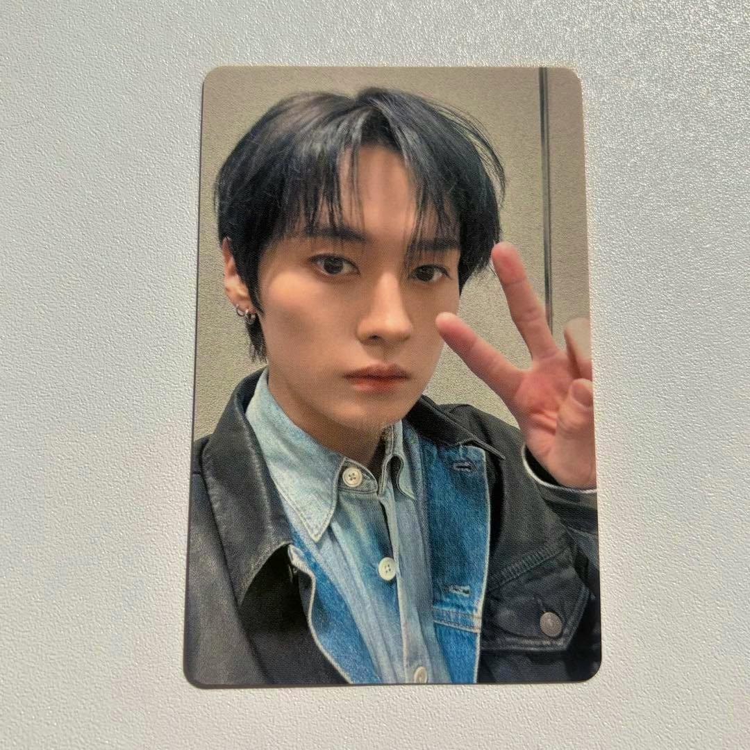 Photocard showing a portrait of a person holding up a peace sign, wearing a denim shirt and jacket.